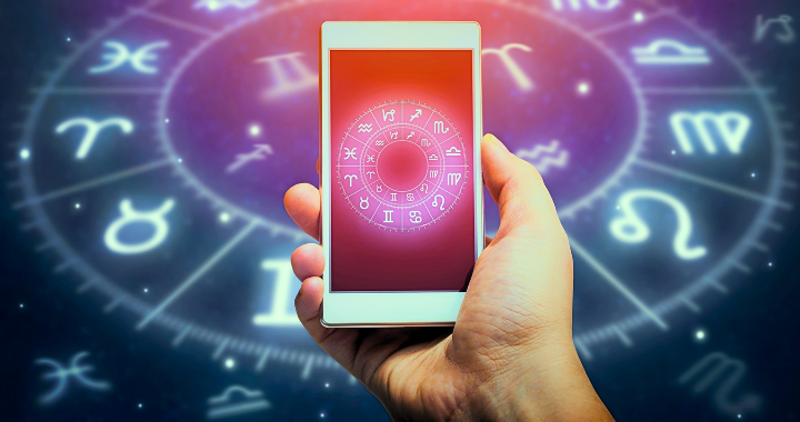 Astrology app on mobile phone with zodiac wheel background